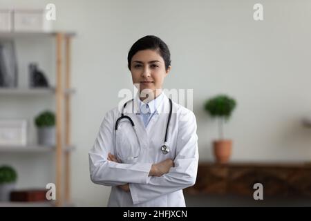 Portrait of smiling confident Indian doctor posing in office. Stock Photo