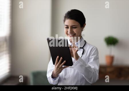 Happy young Indian doctor using digital tablet. Stock Photo