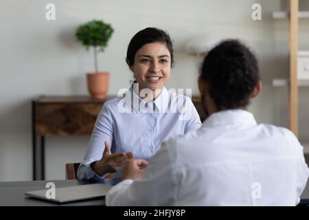 Happy young Indian woman talking with skilled doctor. Stock Photo