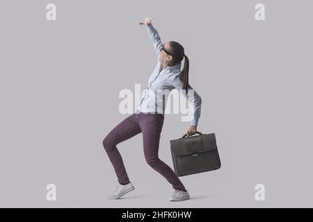 Scared woman protecting herself from a danger, something is falling over her, isolated on gray background Stock Photo