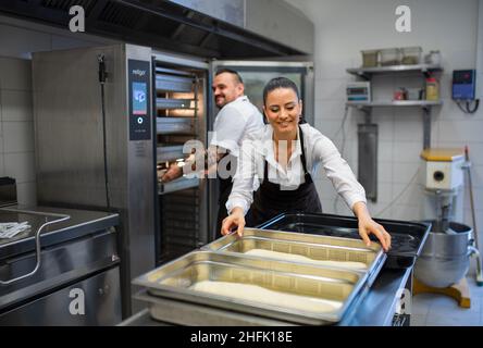 Chef and cook working on their dishes indoors in restaurant kitchen. Stock Photo