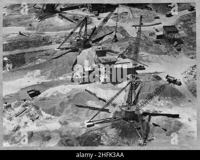 Filton Airfield, South Gloucestershire, 11/06/1947. An aerial view showing derrick cranes and a concrete batching plant amid heaps of aggregate at Filton Airfield, during the construction of a new runway. Laing extended the runway westwards at Filton Airfield to accommodate the Bristol Brabazon airliner, which was being built at the airfield. Work began in July 1946 on the new runway, which was 2,725 yards long and 100 yards wide. The work required the requisitioning and removal of Charlton village and a temporary flying strip was laid, for use while the new runway was under construction. The Stock Photo