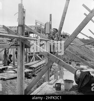 County High School, Gedling Road, Arnold, Gedling, Nottinghamshire, 12/09/1958. A worker up a ladder checking a column is vertical using a spirit level during the construction of Arnold County High School. Work began on the site in March 1958 and construction was completed for the new school term in September 1959. 'Laingspan' was a flexible modular system of frame construction using precast pre-stressed concrete units. Laing developed the system in conjunction with the Architects and Buildings Branch of the Ministry of Education and consulting engineer AJ Harris. The Arnold school was the fir Stock Photo