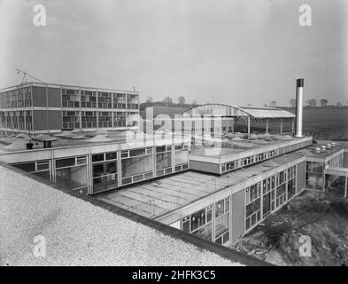 County High School, Gedling Road, Arnold, Gedling, Nottinghamshire, 23/02/1959. A view from the roof of Arnold County High School, looking towards the science block and 'barn-roof' covered athletics space. Whilst the gymnasium at the school was comparatively small it was equipped with a covered outdoor space of 8,000 sq ft for games practice. This area was roofed with a curved 'Dutch Barn' style corrugated iron structure but otherwise open to the outside. Stock Photo