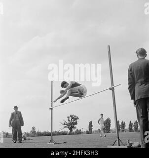 Laing Sports Ground, Rowley Lane, Elstree, Barnet, London, 30/06/1956. A man performing a high jump during a sports day at Laing's Elstree Sports Club. This sports day was attended by Laing staff members and their families, with some travelling to Elstree from as far as Swindon, Leicester and Dagenham. The day consisted of various track and field events as well as attractions for children including fairground rides and performers. Handicraft, cookery, flower and photography competitions were also held, with entries displayed in a marquee at the fete. Stock Photo