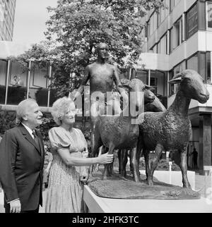 Paternoster Square, City of London, 30/07/1975. Violinist Yehudi Menuhin admiring a bronze sculpture of a shepherd and sheep by Elisabeth Frink (pictured), on the day it was unveiled at the Paternoster development. Work on the Paternoster development in the 1960's was carried out in a joint venture by John Laing Construction Limited, Trollope and Colls Limited, and George Wimpey and Company Limited. The development consisted of a series of office blocks, a shopping precinct, an extensive piazza and a three-level car park. In July 1975, a bronze statue of a shepherd and his sheep, sculpted by E Stock Photo