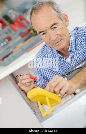 a senior serviceman using multimeter Stock Photo