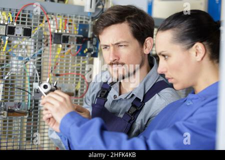 teacher observing students working on electrical circuits Stock Photo