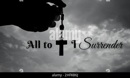 Christianity inspirational message - All to Jesus I surrender quote. With hand holding Rosary and sky background. Stock Photo