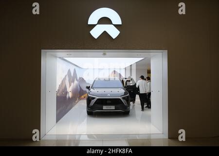 NIO EV store logo. NIO electric car and Chinese customers in store. Chinese EV company Stock Photo