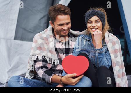 Young nice couple having fun on camping with heart shape Stock Photo