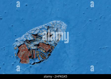 rusting blue iron door. Macro texture of peeling blue paint on a rusty metal surface with cracked layers Stock Photo