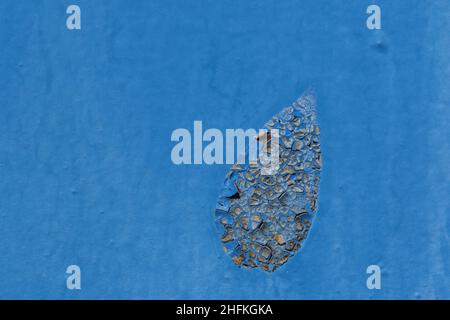 rusting blue iron door. Macro texture of peeling blue paint on a rusty metal surface with cracked layers Stock Photo