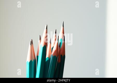 Green set of graphite pencils on sunny white wall background. Stock Photo
