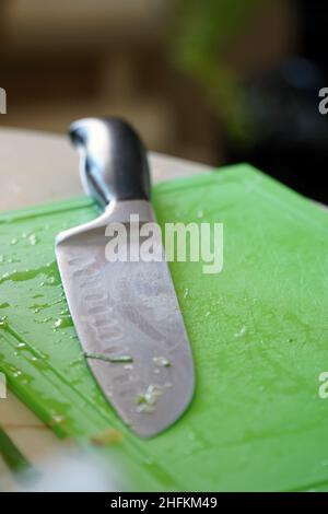 Kitchen knife on a green plastic cutting board Stock Photo