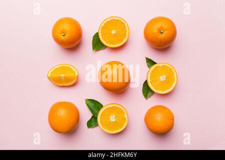 Fruit pattern of fresh orange slices on colored background. Top view. Copy Space. creative summer concept. Half of citrus in minimal flat lay. Stock Photo