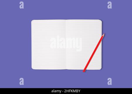 School or office notebook with red pencil isolated on purple background. Top view. Mock up. Stock Photo