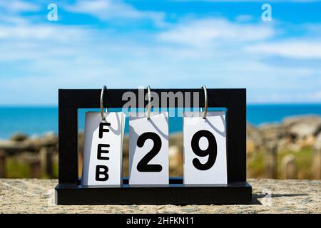 Feb 29 calendar date text on wooden frame with blurred background of ocean. Calendar concept Stock Photo