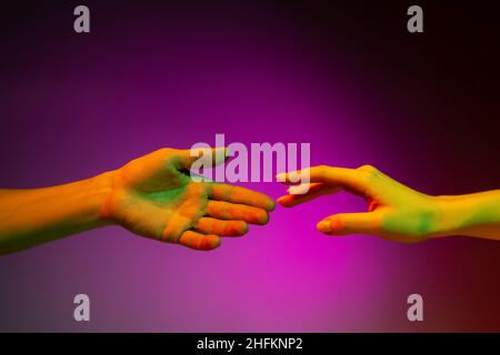 Two painted hands trying to touch each other isolated on white ...