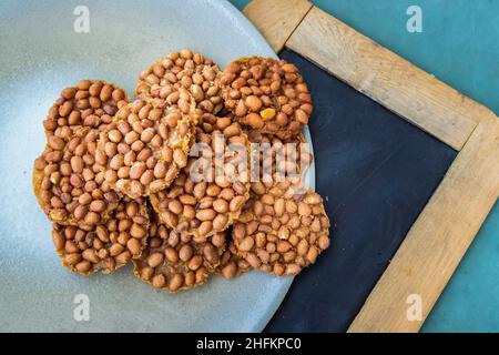 Traditional Thai Snack : Peanut crackers made from nuts and flour to fry on plate. Deep Fried Bean cookies peanut, Top view, Selective focus. Stock Photo