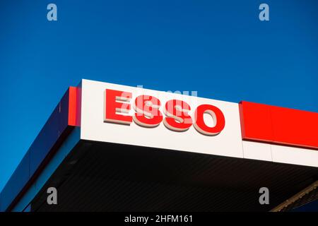 Esso gas station forecourt roof signage against bright blue clear sky. Stock Photo