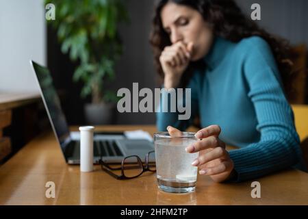 Sick female employee coughing and suffering from flu, taking antipyretic medications at workplace Stock Photo