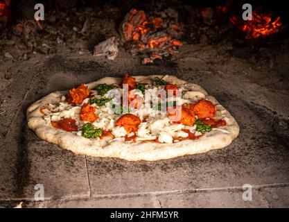 Wood fired rustic pizza in pizza oven Stock Photo