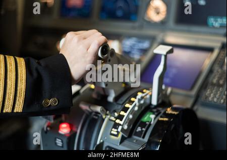 Female pilot's hand on the plane engine control stick. Stock Photo