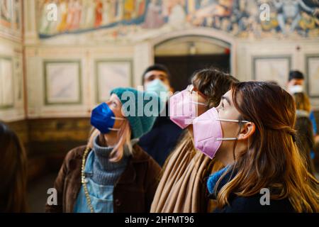 Young female visitors wear anti covid masks in Scrovegni Chapel. Padua, Italy - January 2022 Stock Photo