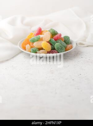 jujube, colorful gummy type of candy confectionery on a white plate, taken in shallow depth of field with copy space Stock Photo