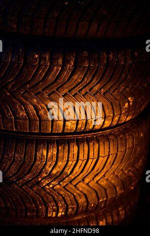 Set of all-season tires in the trunk of the car, four interchangeable tires, warm yellow light on the tires to the wheels of the car. Stock Photo