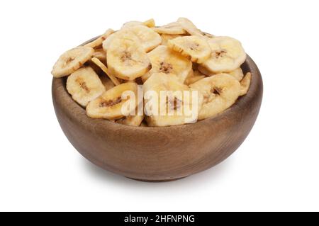 Studio shot of dried banana chips in a wooden bowl cut out against a white background - John Gollop Stock Photo