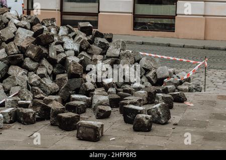 Old damaged cobbled road, concrete street pavement Stock Photo