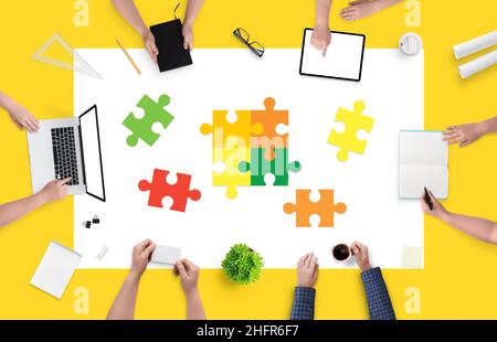 Employees in the company solve puzzles. The concept of solving problems and tasks in the company. Working together on a project. Top view, flat lay Stock Photo