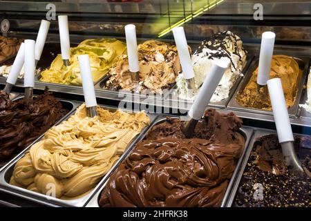 Refrigerated counter with display of various flavors of ice cream Stock Photo