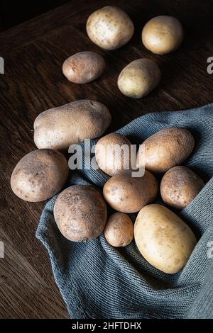 Potatoes from the garden on a rustic wooden kitchen table Stock Photo