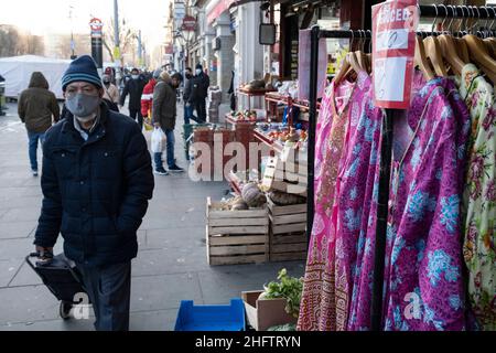 Street scene along Whitechapel High Street on 13th January 2022 in London, United Kingdom. Some people are seen wearing face masks and others not as life under Coronavirus continues. Whitechapel, a very ethnically diverse and vibrant neighbourhood in the East End is home to a significant population of Bangladeshi residents. This can be seen along the pavements where Whitechapel Market and the surrounding shops interact with this truly multicultural society. Stock Photo