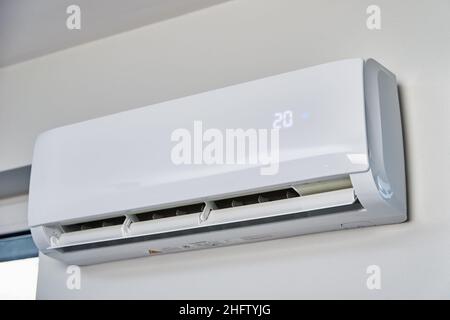 Adjusting temperature on air conditioner, Working air conditioner for comfort temperature in home at hot summer, cooling air in the room Stock Photo