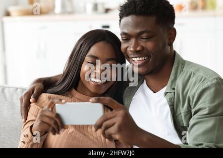 Happy african american lovers taking selfie on cellphone Stock Photo