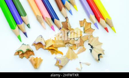Color pencils with shavings arranged to form a rainbow on white background. Stock Photo