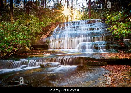 Sun setting over Grogan Creek Falls (or Falls on Grogan Creek) located in Pisgah National Forest near Brevard NC. Stock Photo