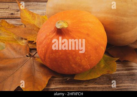 pumpkin and butternut on a wooden table with autumn leaves Stock Photo