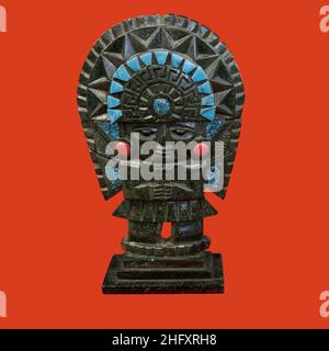 a decorative mayan statuette isolated on a red background Stock Photo