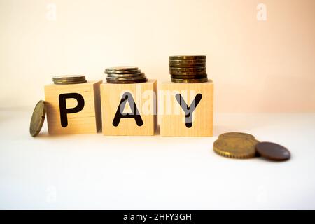 Hand is turning a dice and changes the word Pay to Day Stock Photo