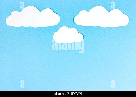Bright blue sky with white paper clouds as a craft textured heaven template or cloudscape background with copy space. Stock Photo