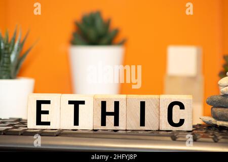 Wooden blocks with the word Ethic. Defending, systematizing and recommending concepts of right and wrong conduct. Moral philosophy Stock Photo