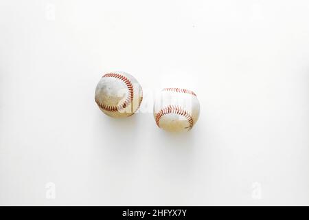 A pair of used baseballs isolated on a white surface or background; baseball America's National pastime; American sports. Stock Photo