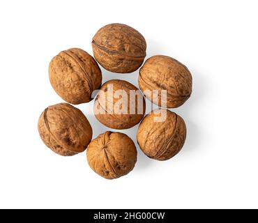 Unshelled walnuts heap isolated on a white background. Juglans regia tree fresh tasty fruits macro. Whole nuts in their shells cutout. Vegetarian food Stock Photo
