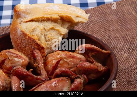 Rustic dinner. Roasted quail meat and white bread. Close-up Stock Photo