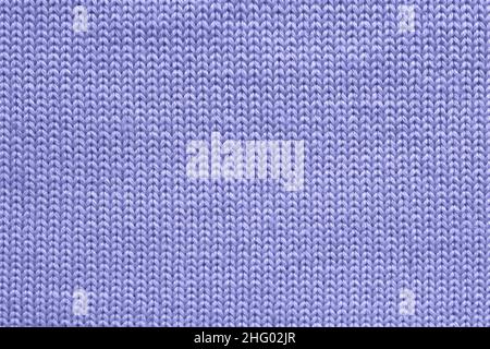 Texture of blue violet wool knitted sweater closeup. Abstract stockinette fabric background in trendy color of the year 2022 very peri. Design element Stock Photo